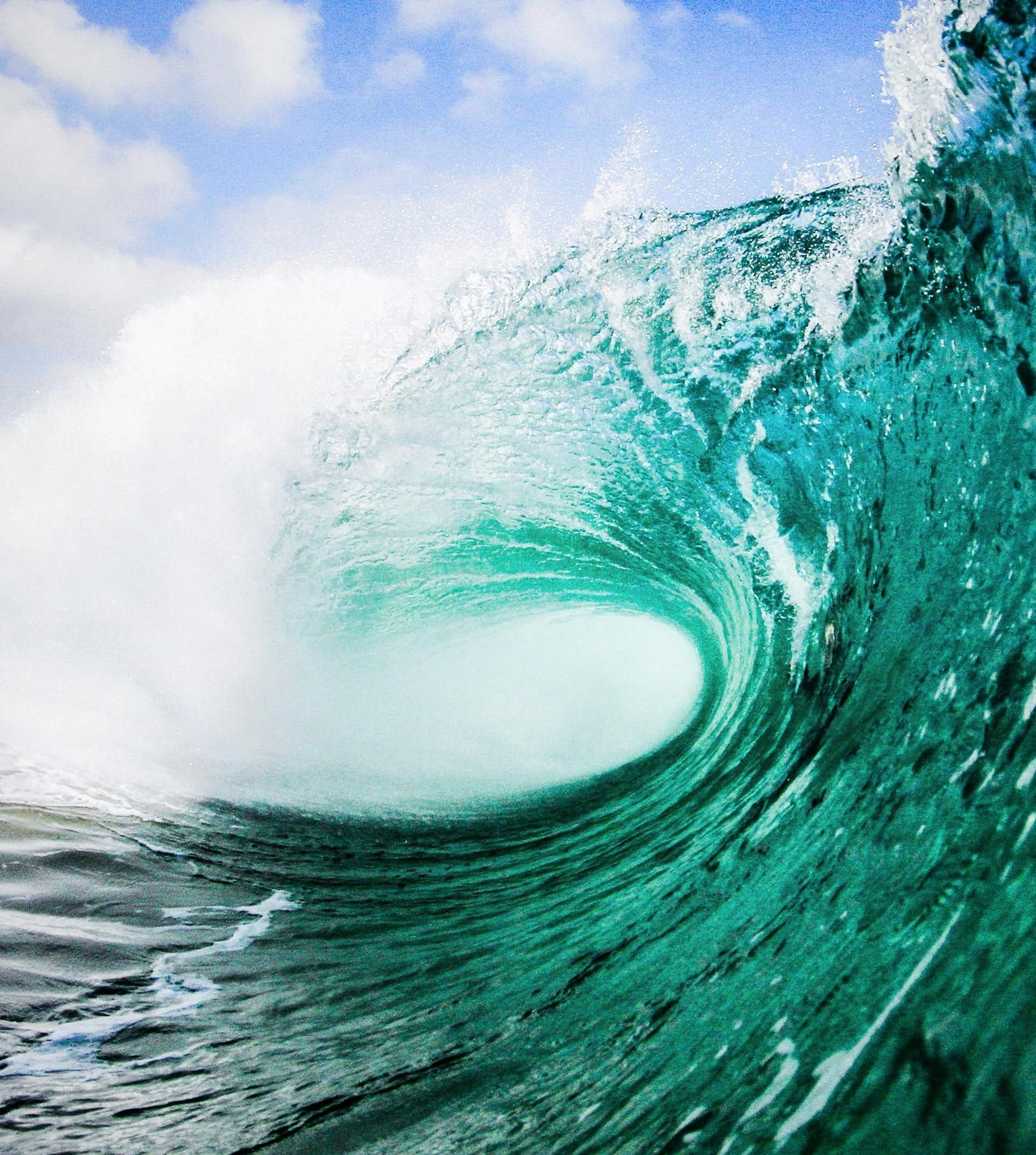 Two people are standing on top of a mountain with their arms outstretched.