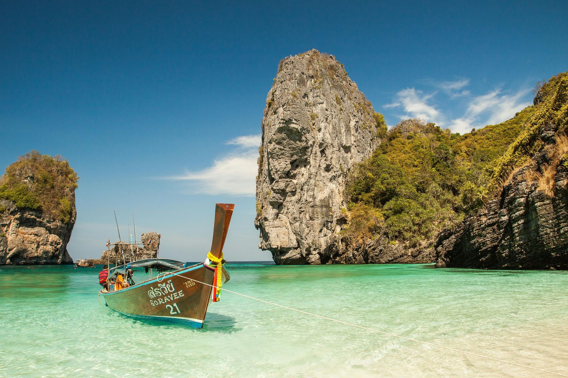 A boat is sitting in the water on a beach.