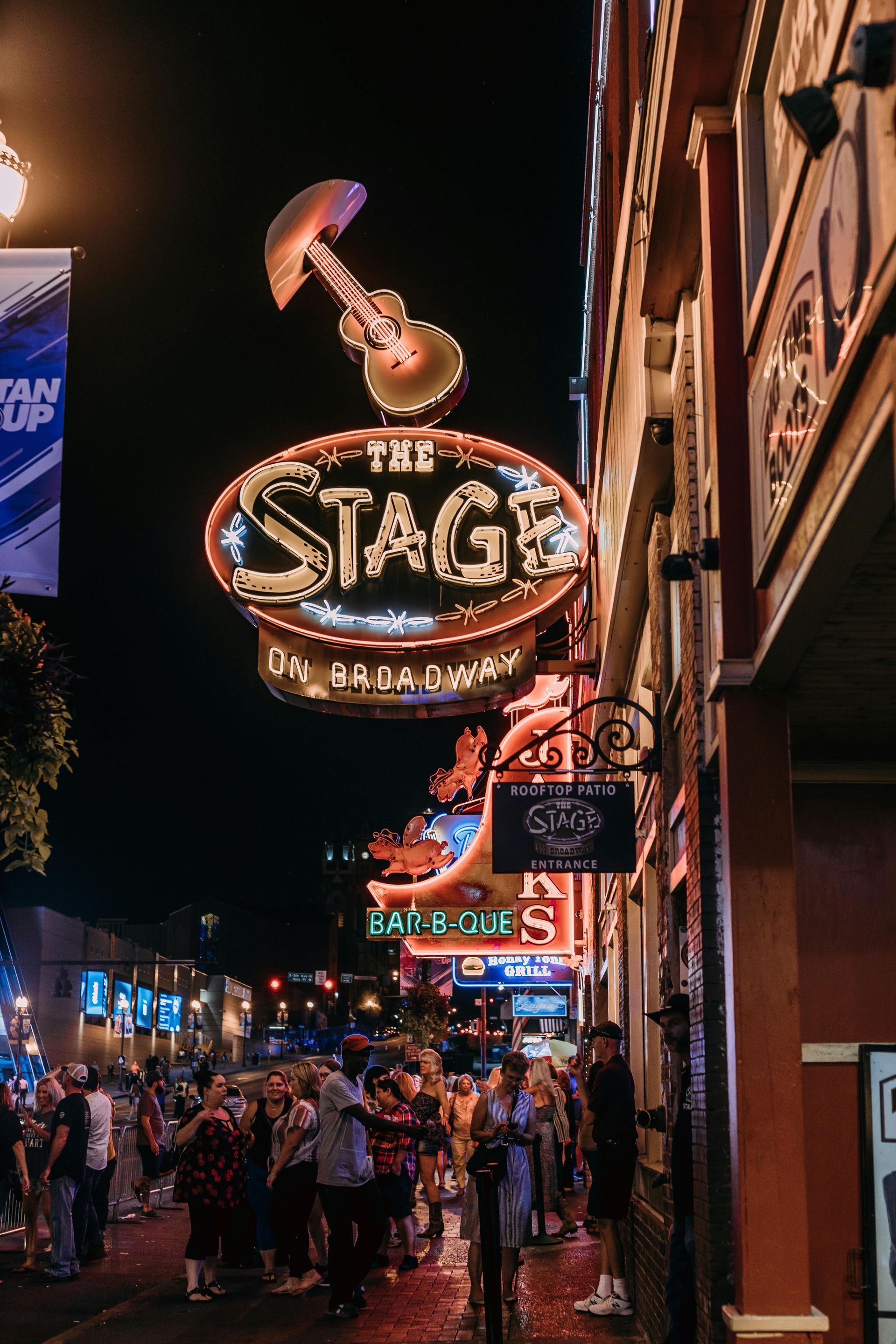 A neon sign for the stage is lit up at night.