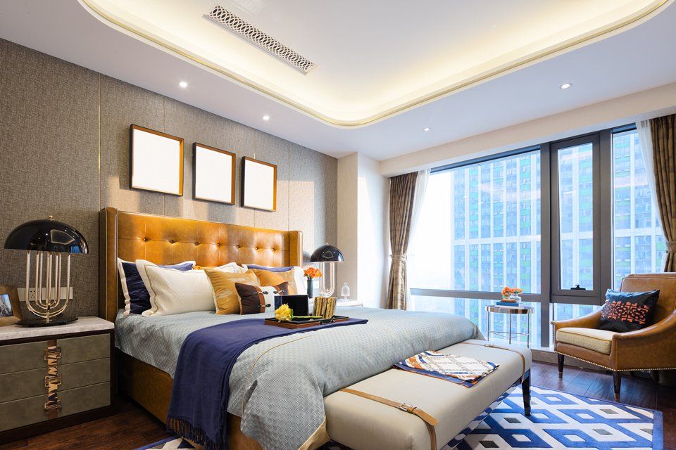 A bedroom with a bed , chair , nightstand , and large window.