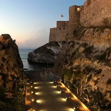 Un castillo se encuentra en lo alto de un acantilado con vistas al océano.