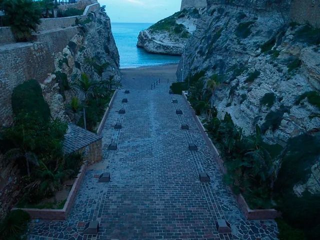Una escalera que conduce a un acantilado con vistas al océano.