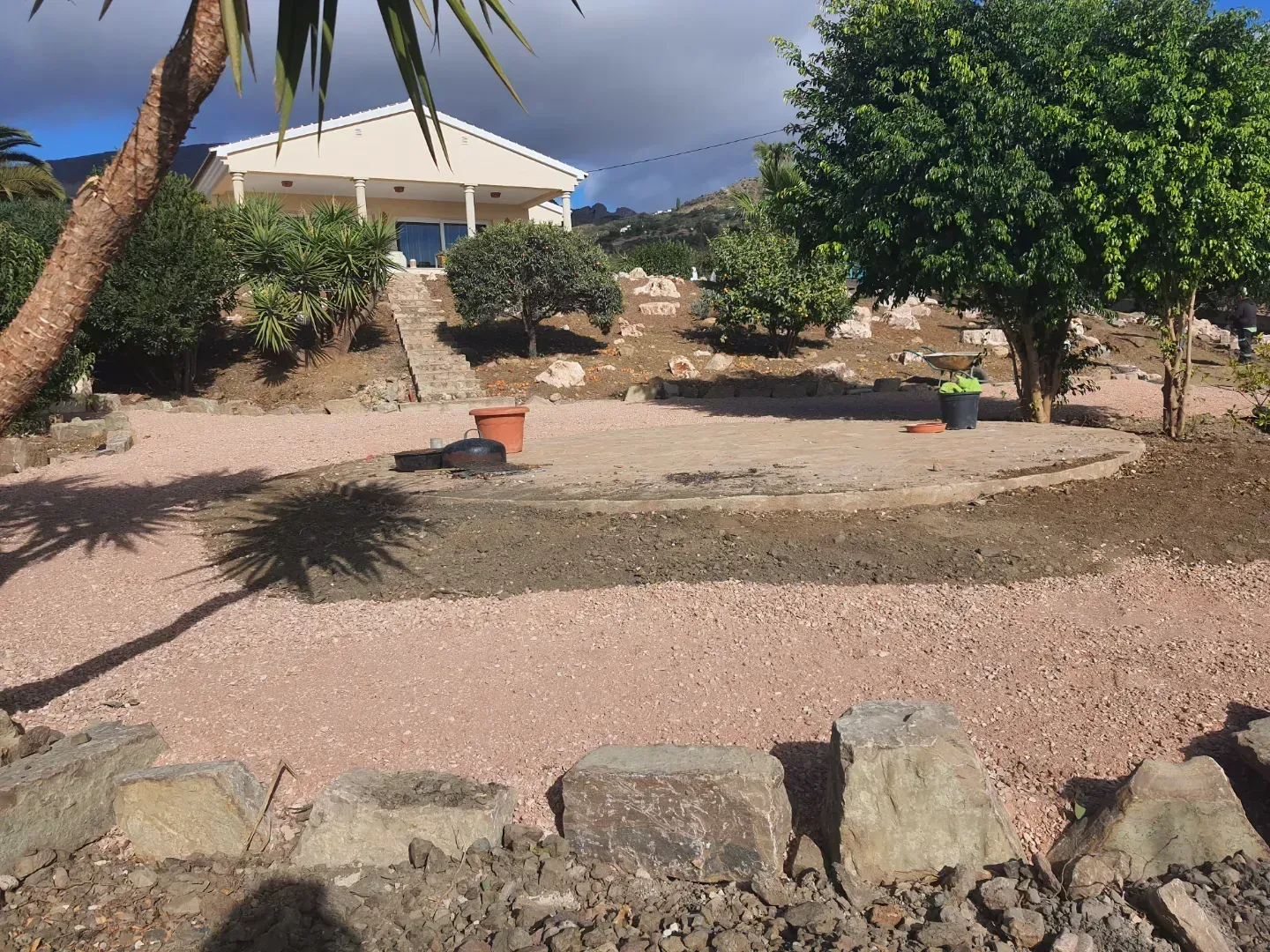 Una gran casa blanca está rodeada de árboles y rocas.