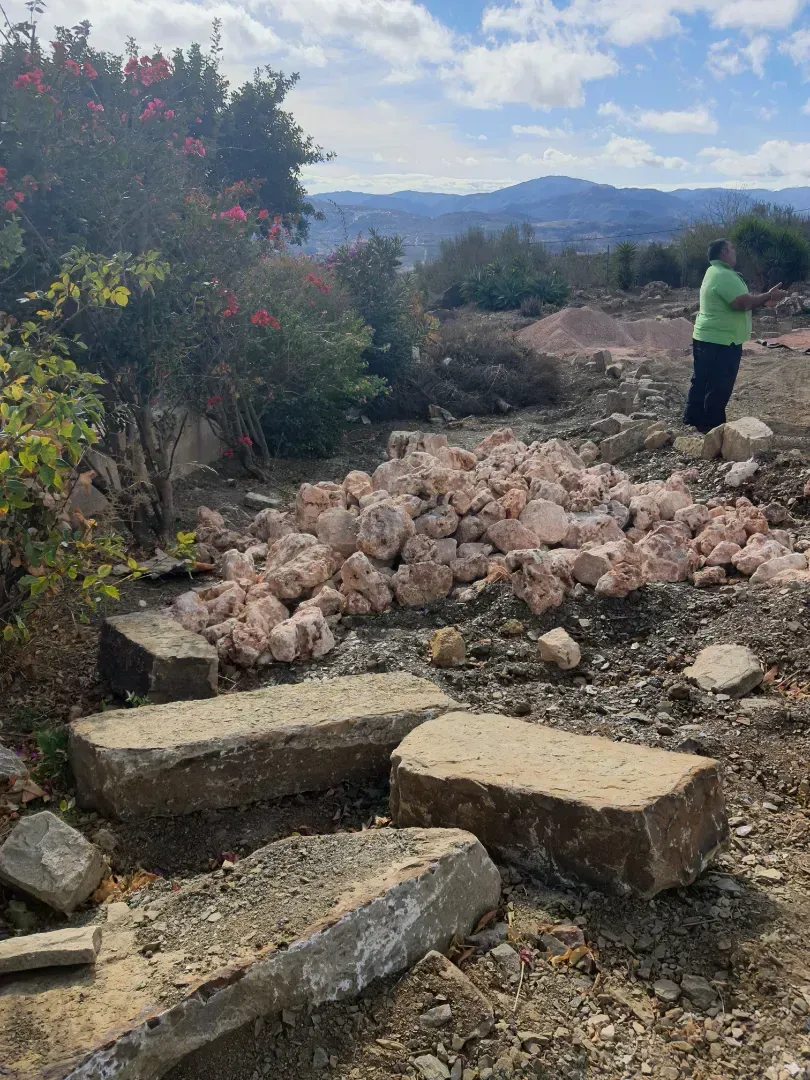 Una mujer con una camisa verde está parada en una pila de rocas.