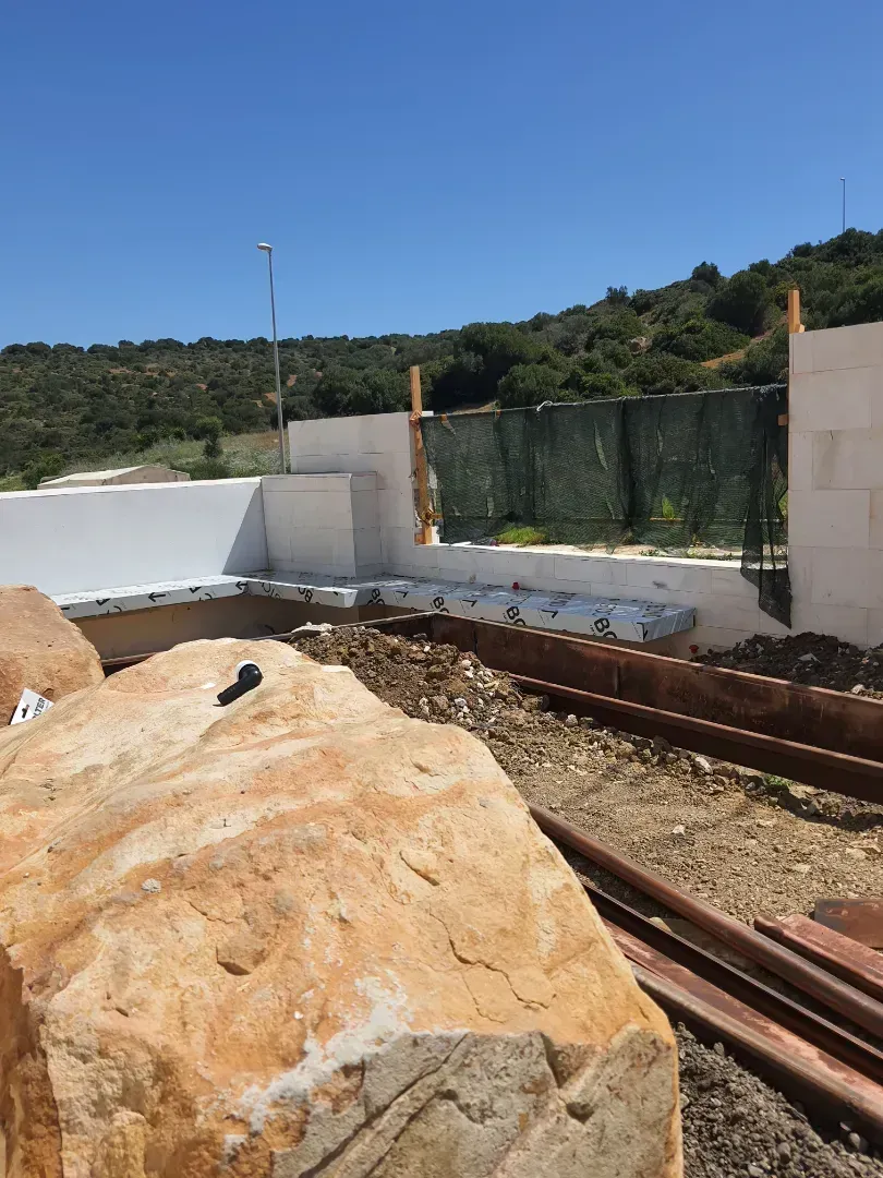 Una gran roca se encuentra en el medio de un campo de tierra.