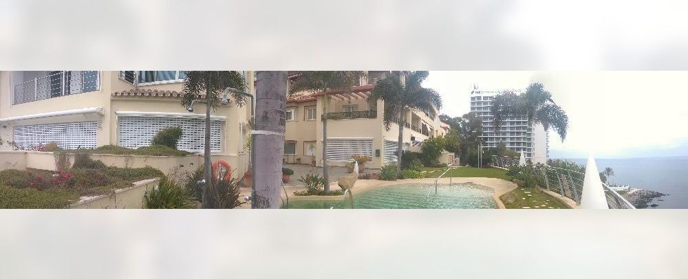 Un gran edificio con una piscina en frente.