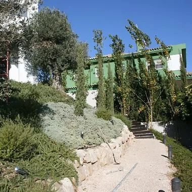 Un camino de grava conduce a un edificio verde.