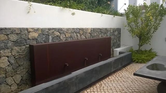 Un muro de piedra con una fuente en el medio.