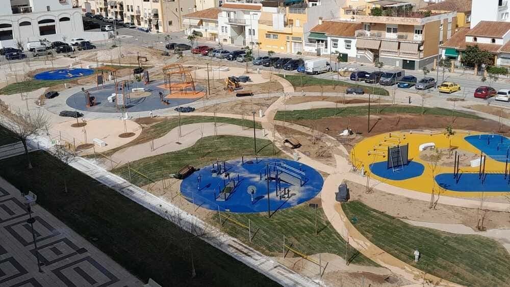 Una vista aérea de un parque con un patio de juegos azul y amarillo.