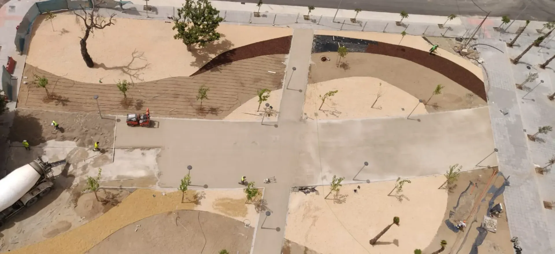 Una vista aérea de un parque con una pasarela de hormigón y árboles.