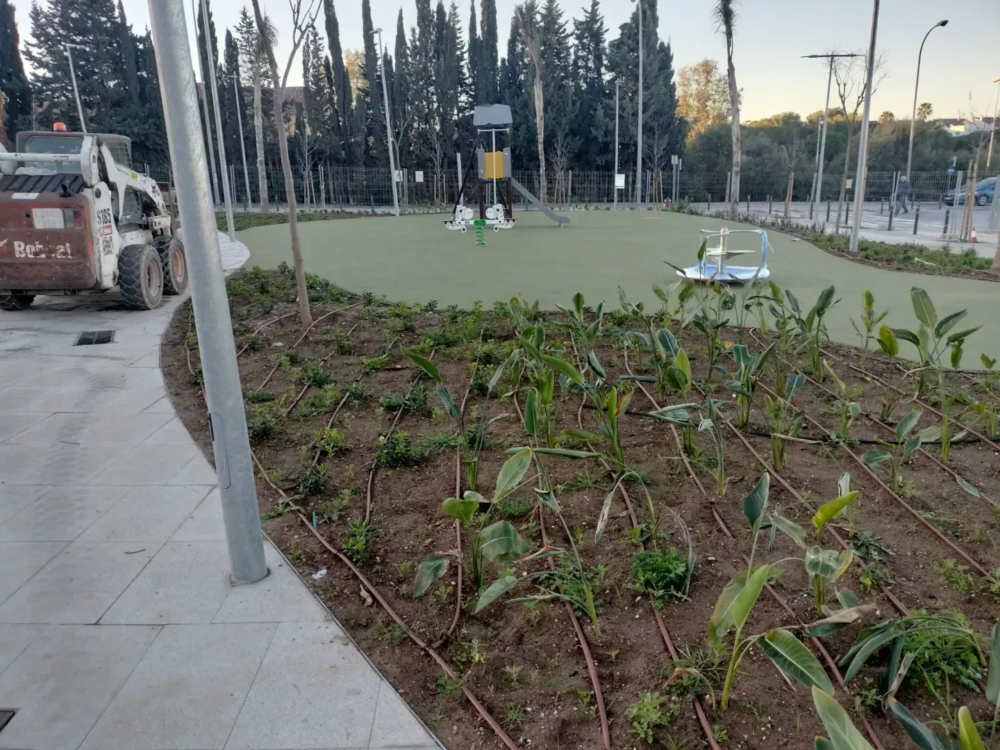 Un lince está estacionado frente a un patio de juegos en un parque.