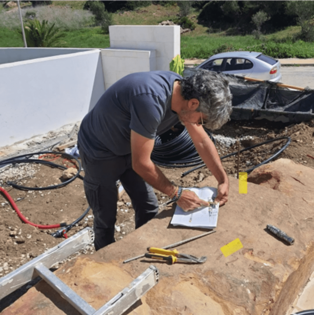 Un hombre está trabajando en un trozo de papel en la tierra.