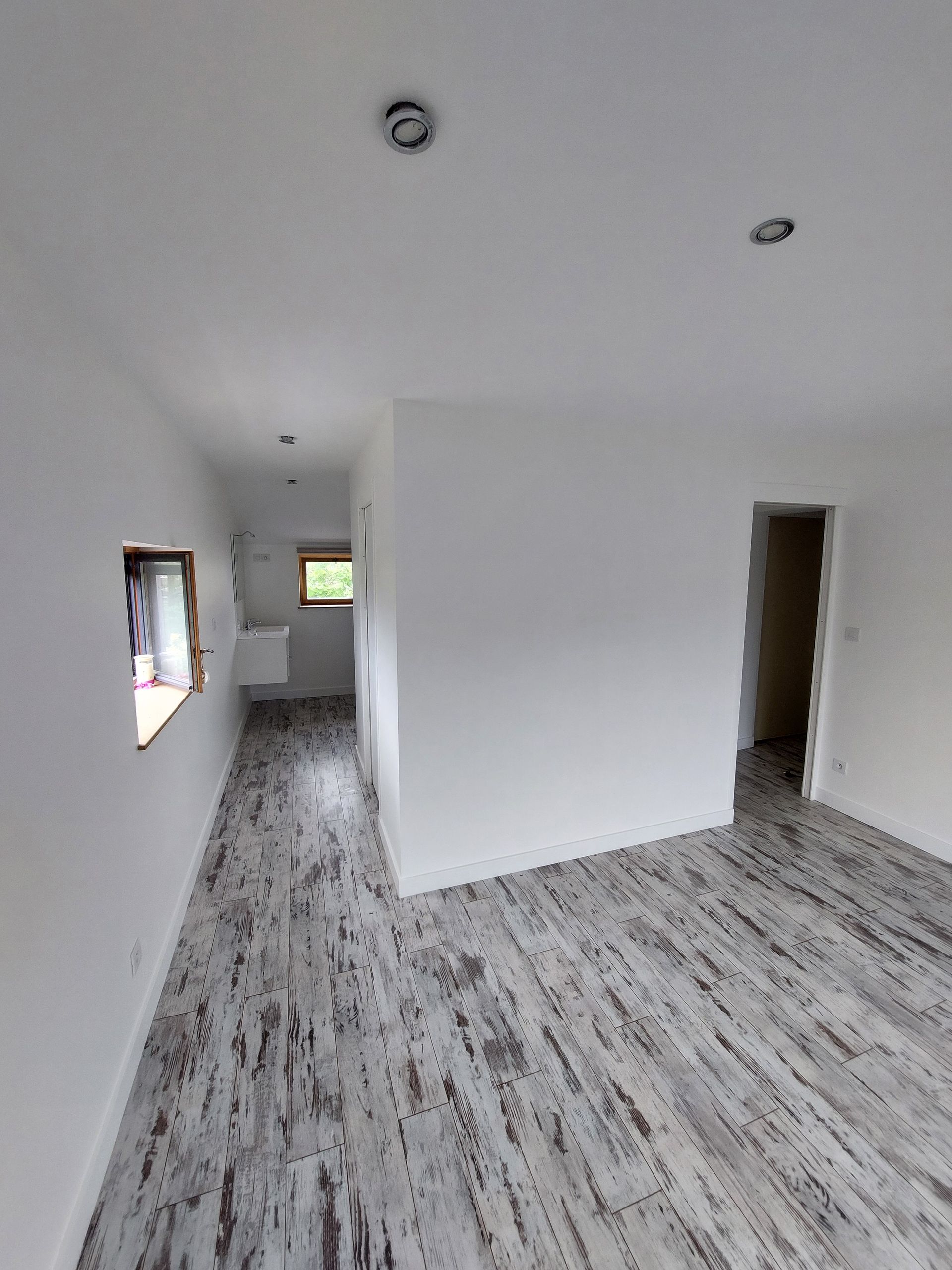 Parquet gris tacheté et murs blancs dans une pièce