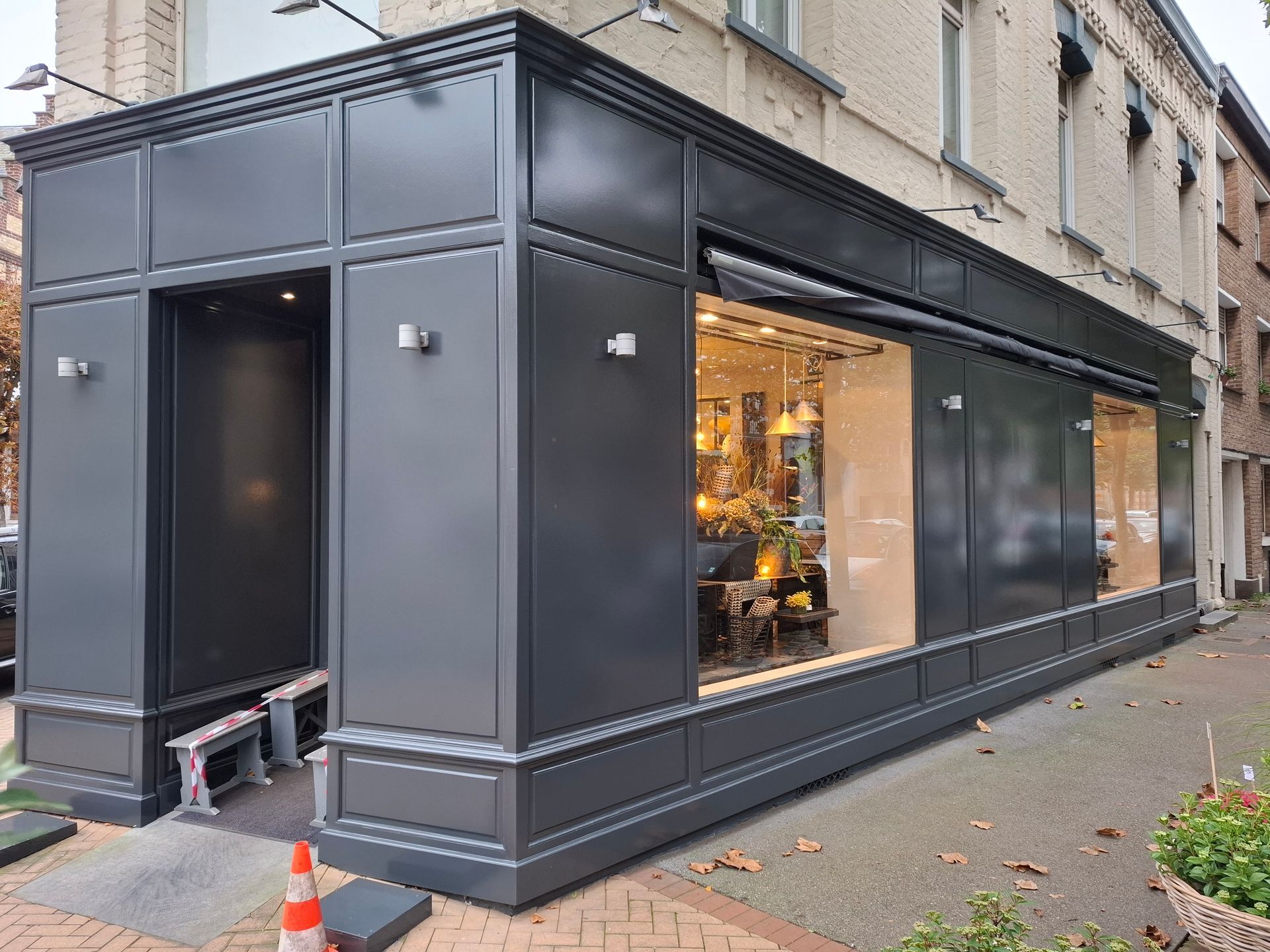 Peinture grise rénovée sur la devanture en boiserie d'une boutique