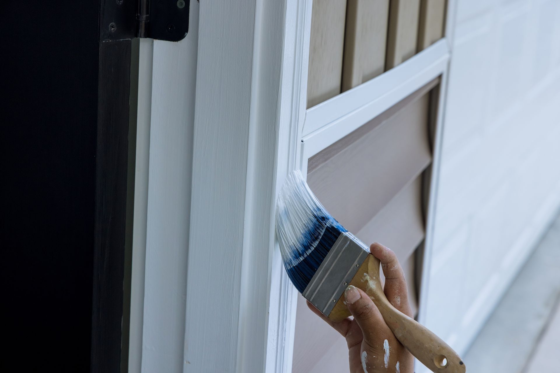 Main repeignant l'encadrement d'une porte blanche