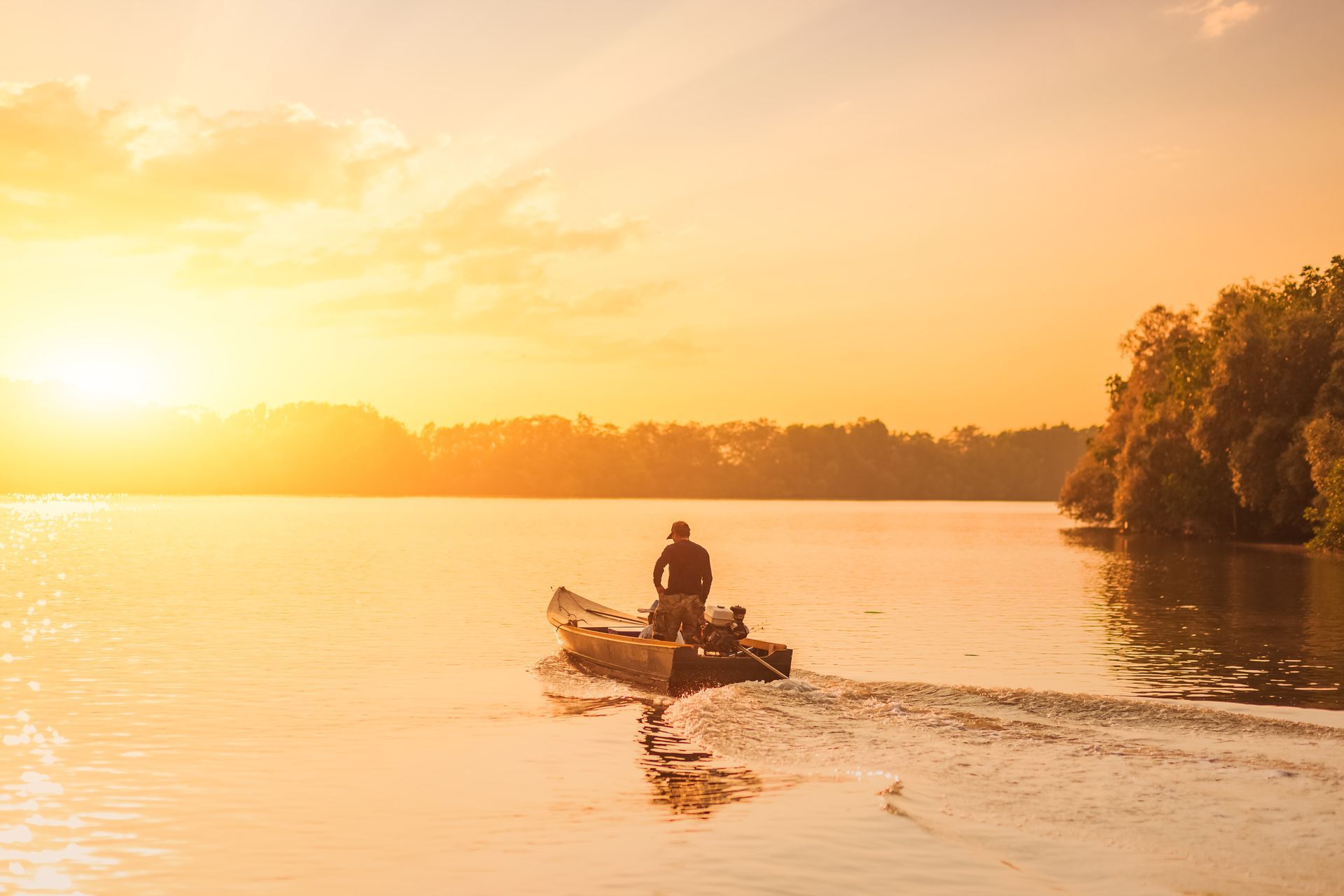 Homme sur un bateau de pêche en pleine rivière
