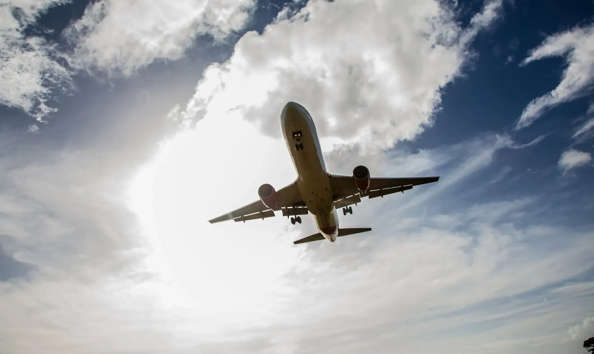 Avión volando hacia la cámara contra un cielo nublado.