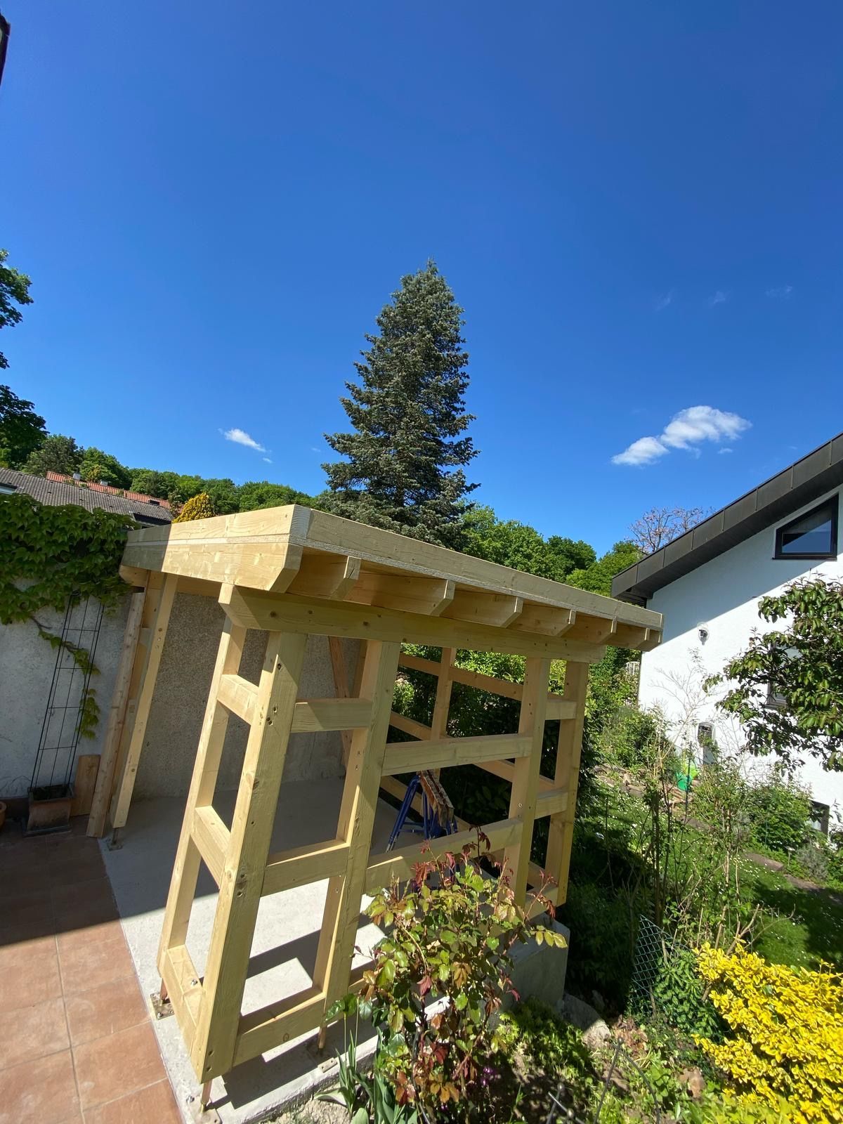 Eine Person bearbeitet in einer Werkstatt mit einem Holzhammer einen Holzrahmen und fertigt dabei Möbel an.