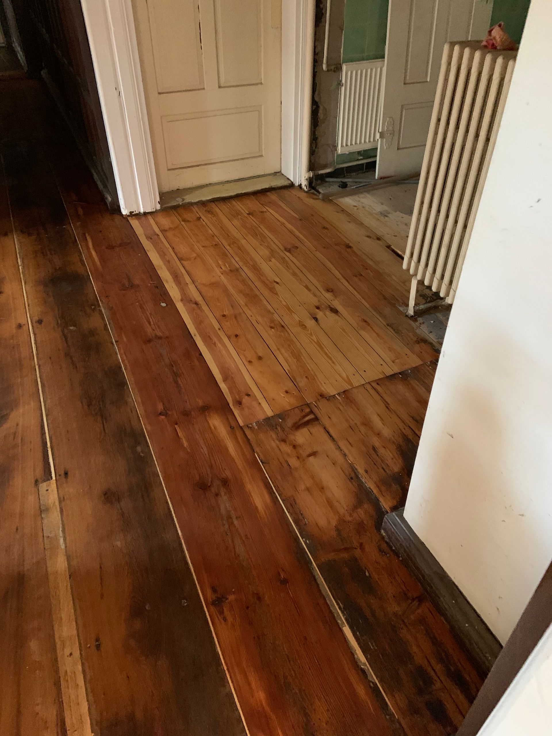 Die Hände eines Holzbearbeiters, der in einer Werkstatt Holz vermisst und mit Werkzeugen bearbeitet.