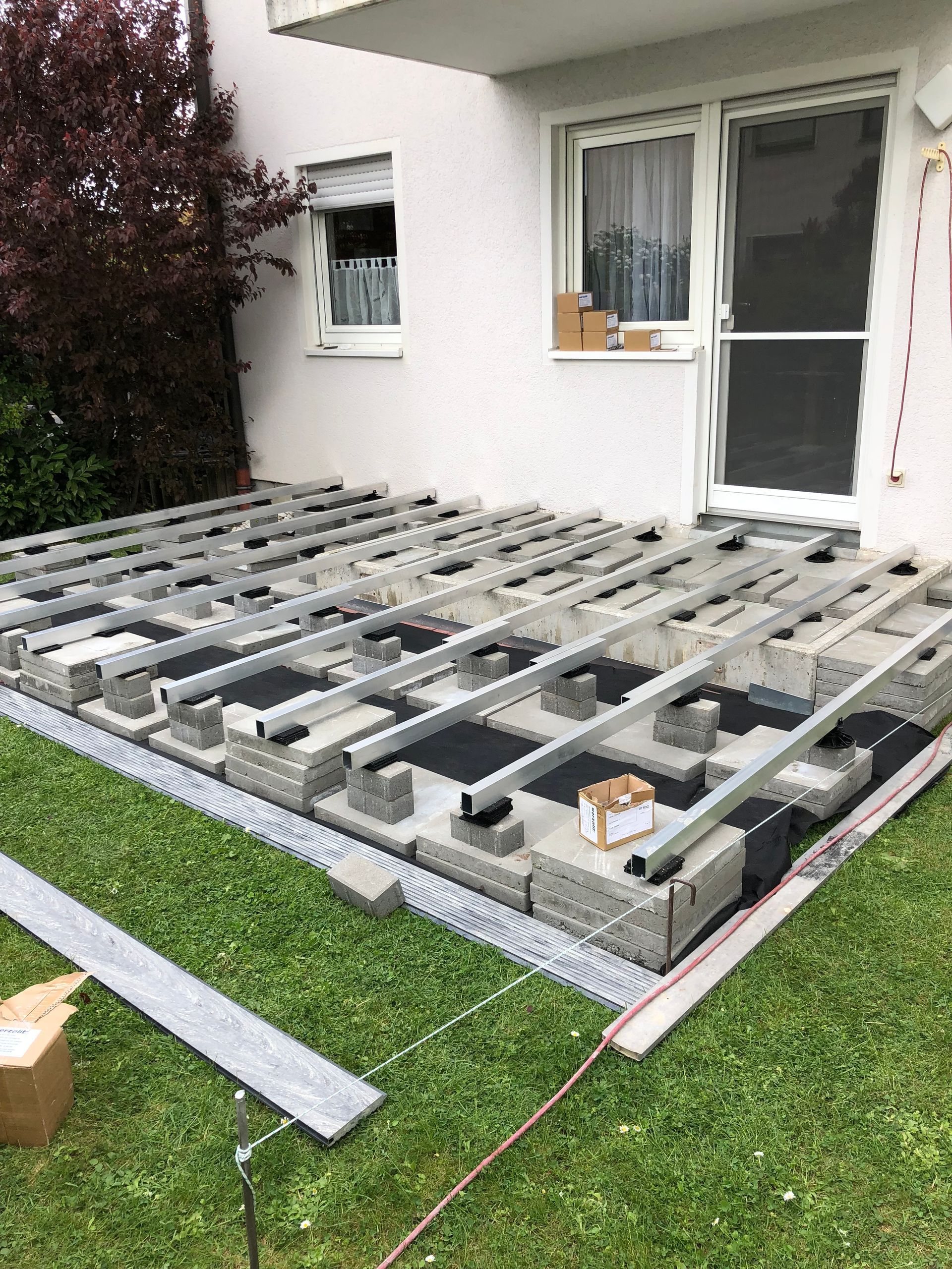 Eine Person schneidet mit einer Kreissäge ein Stück Holz, Sägemehl fliegt umher.