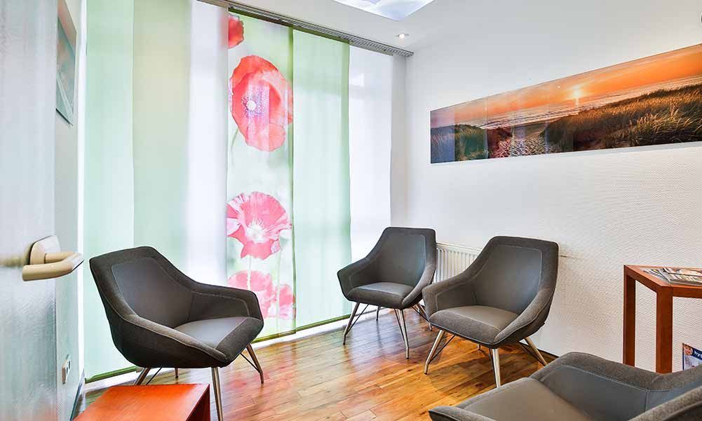 Ein Wartezimmer mit Stühlen und einem Bild an der Wand.