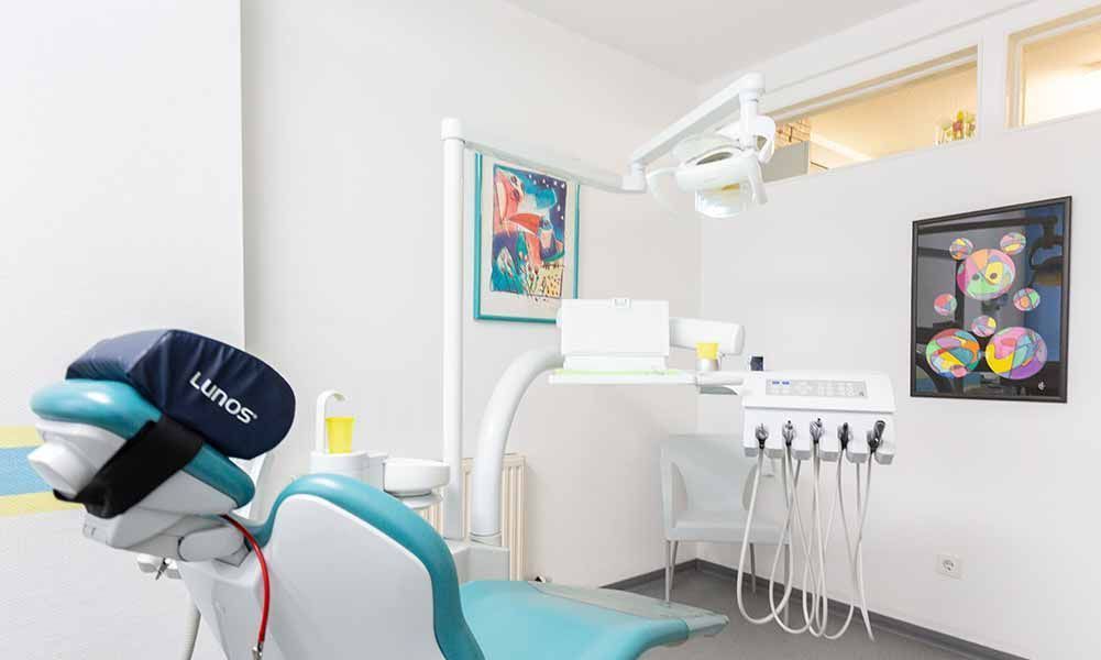 Eine Zahnarztpraxis mit einem Zahnarztstuhl und einem Gemälde an der Wand.