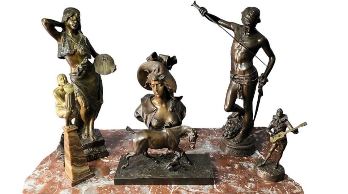 Sculptures en bronze sur un socle en marbre rougeâtre ; figures de femmes, d'un homme avec une corne et d'un taureau.