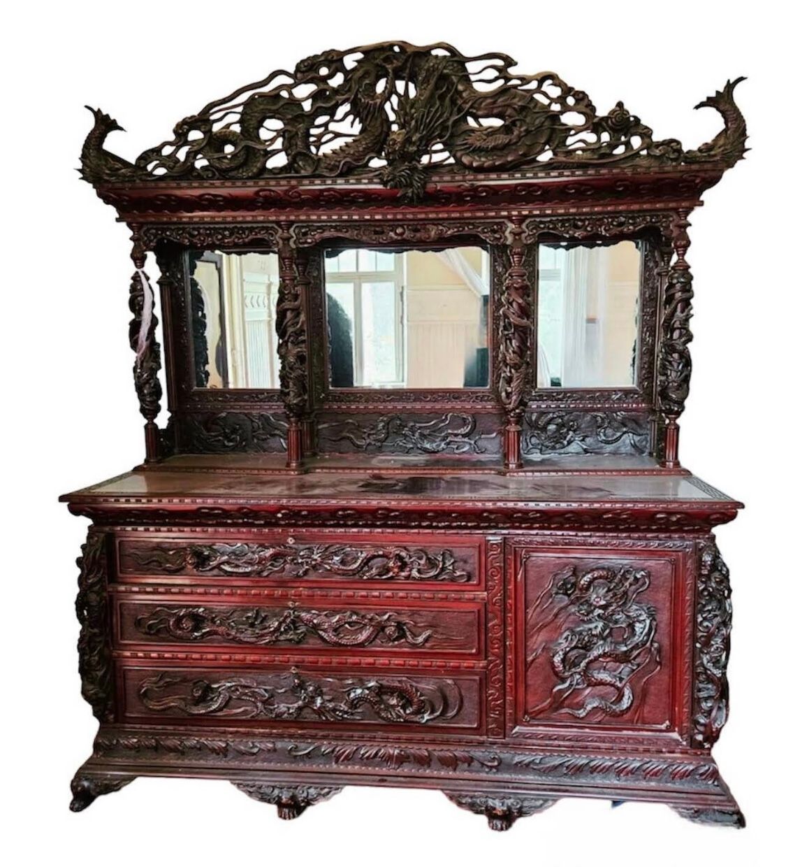 Coiffeuse ancienne rouge foncé, finement sculptée, avec trois miroirs et des tiroirs.