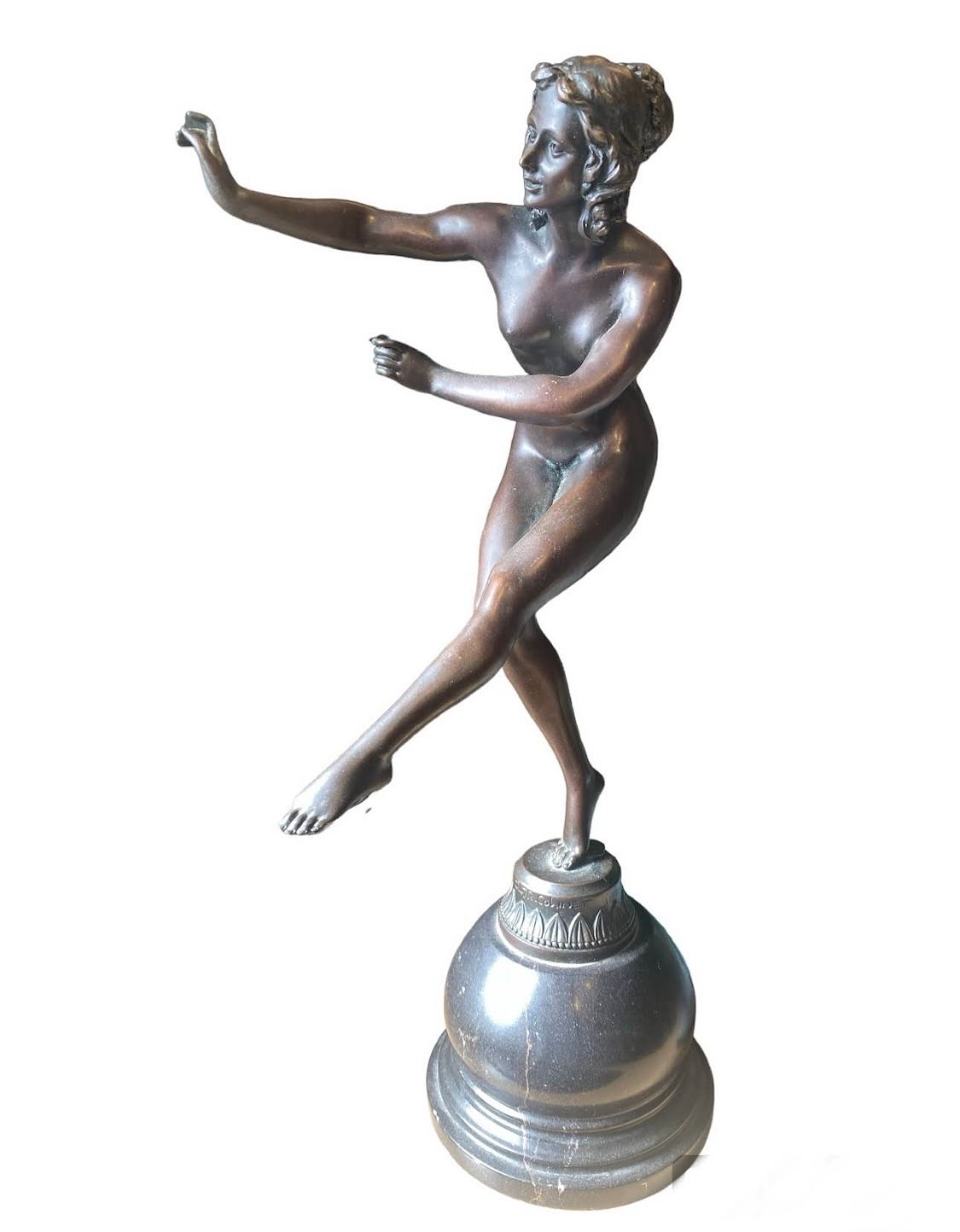 Statue en bronze d'une danseuse nue sur un piédestal, les bras étendus, en équilibre sur un pied.