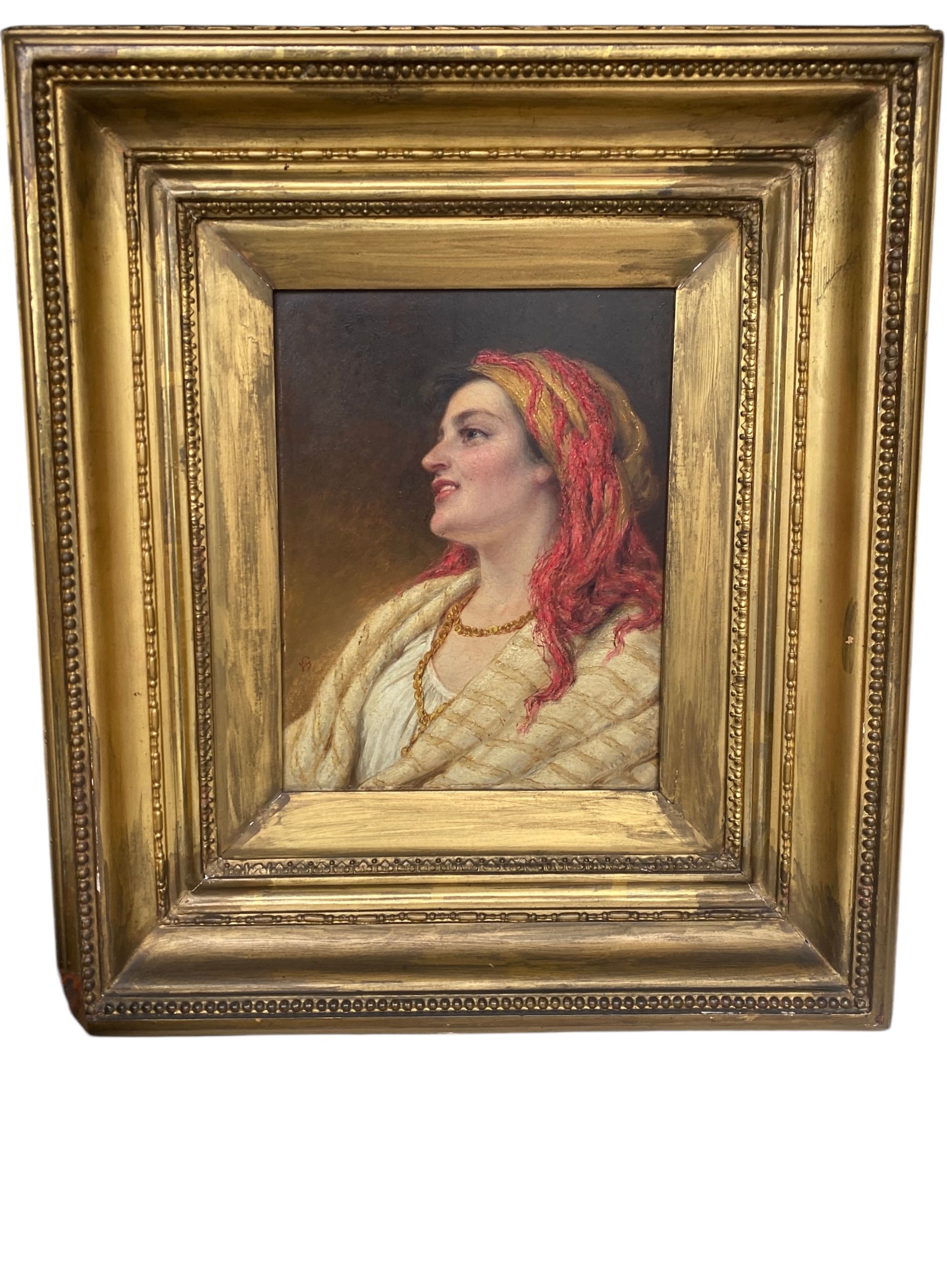 Portrait encadré d'une femme de profil portant un foulard rouge et un châle léger.