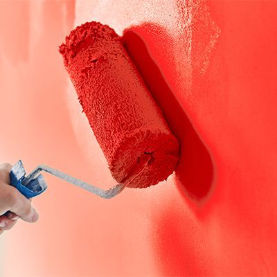 Rouleau de peinture et peinture rouge en gros plan