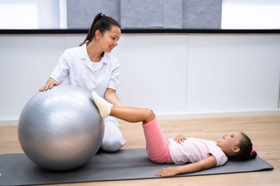 Person arbeitet mit einem Kind für die Physiotherapie