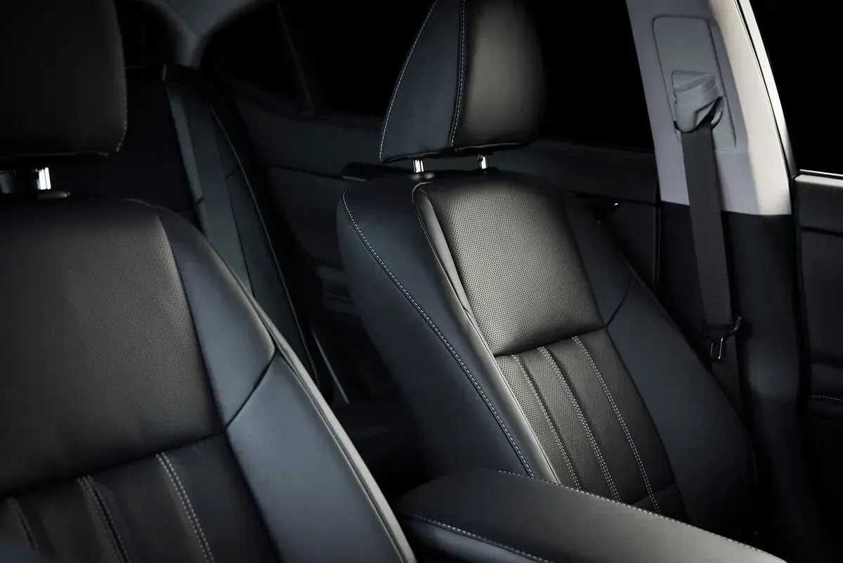El interior de un coche con asientos de cuero negro.