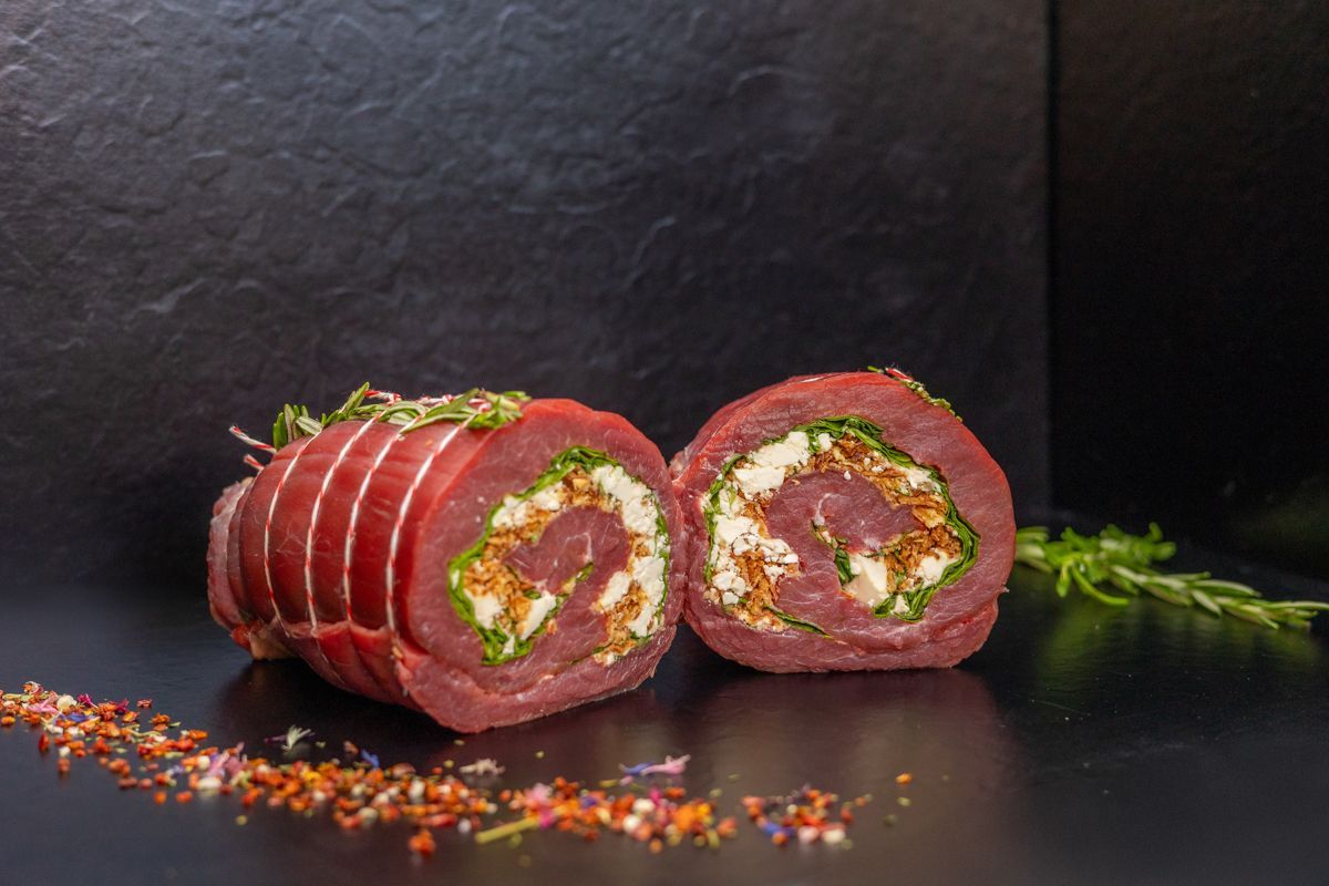 Eine Nahaufnahme eines Stücks Fleisch mit Gemüse auf einem Tisch.