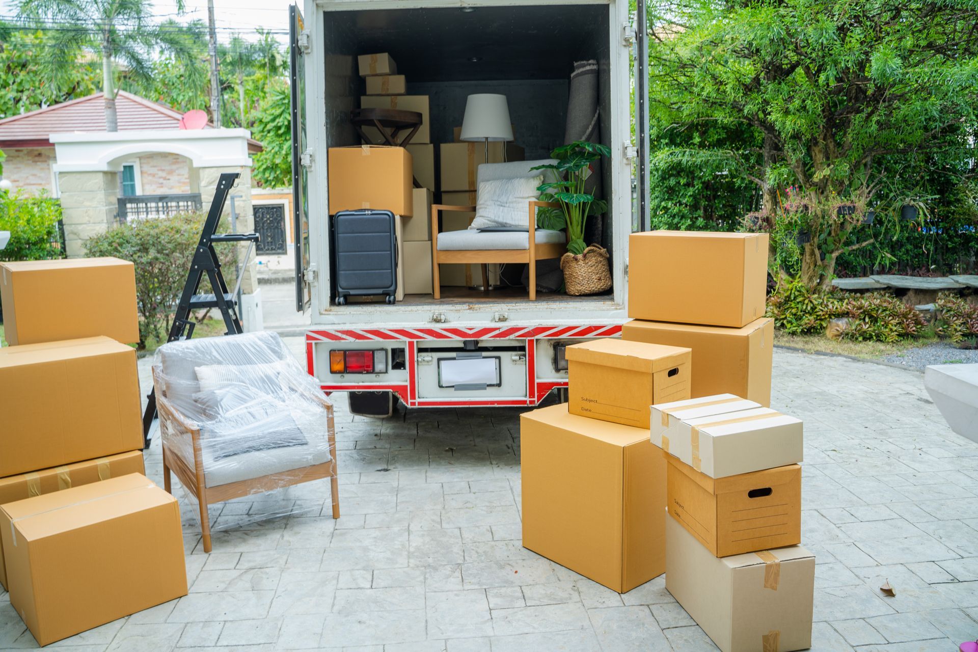 Cartons et meuble devant un camion de chargement