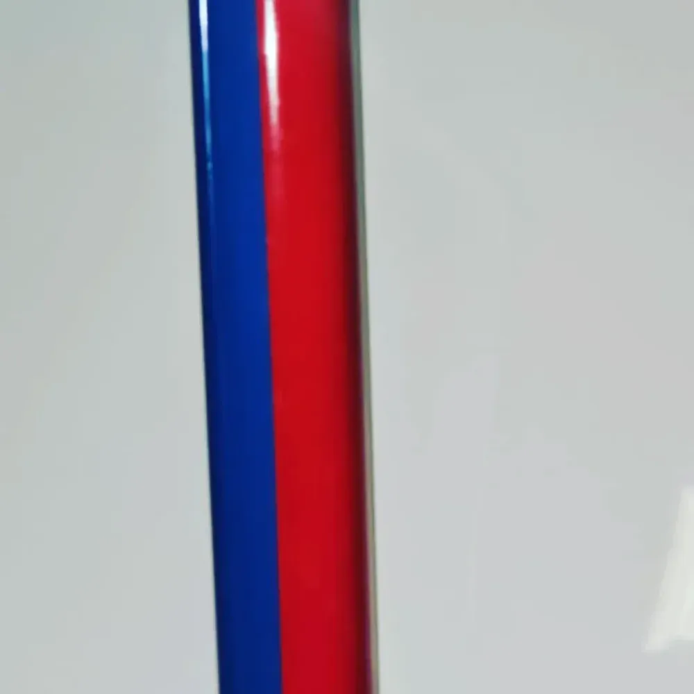 Primer plano de varillas verticales de plástico rojas y azules sobre un fondo claro.