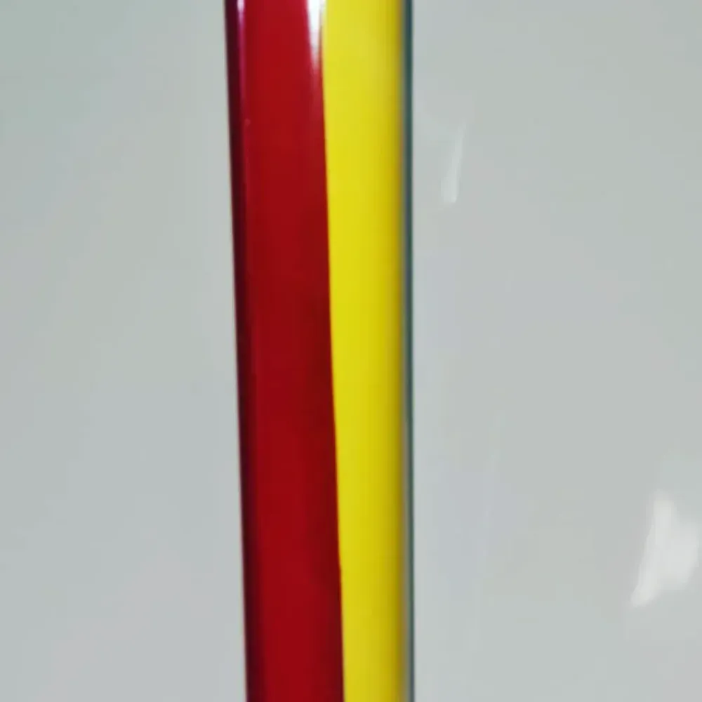 Primer plano de dos franjas verticales brillantes, una roja y otra amarilla, sobre un fondo gris claro.