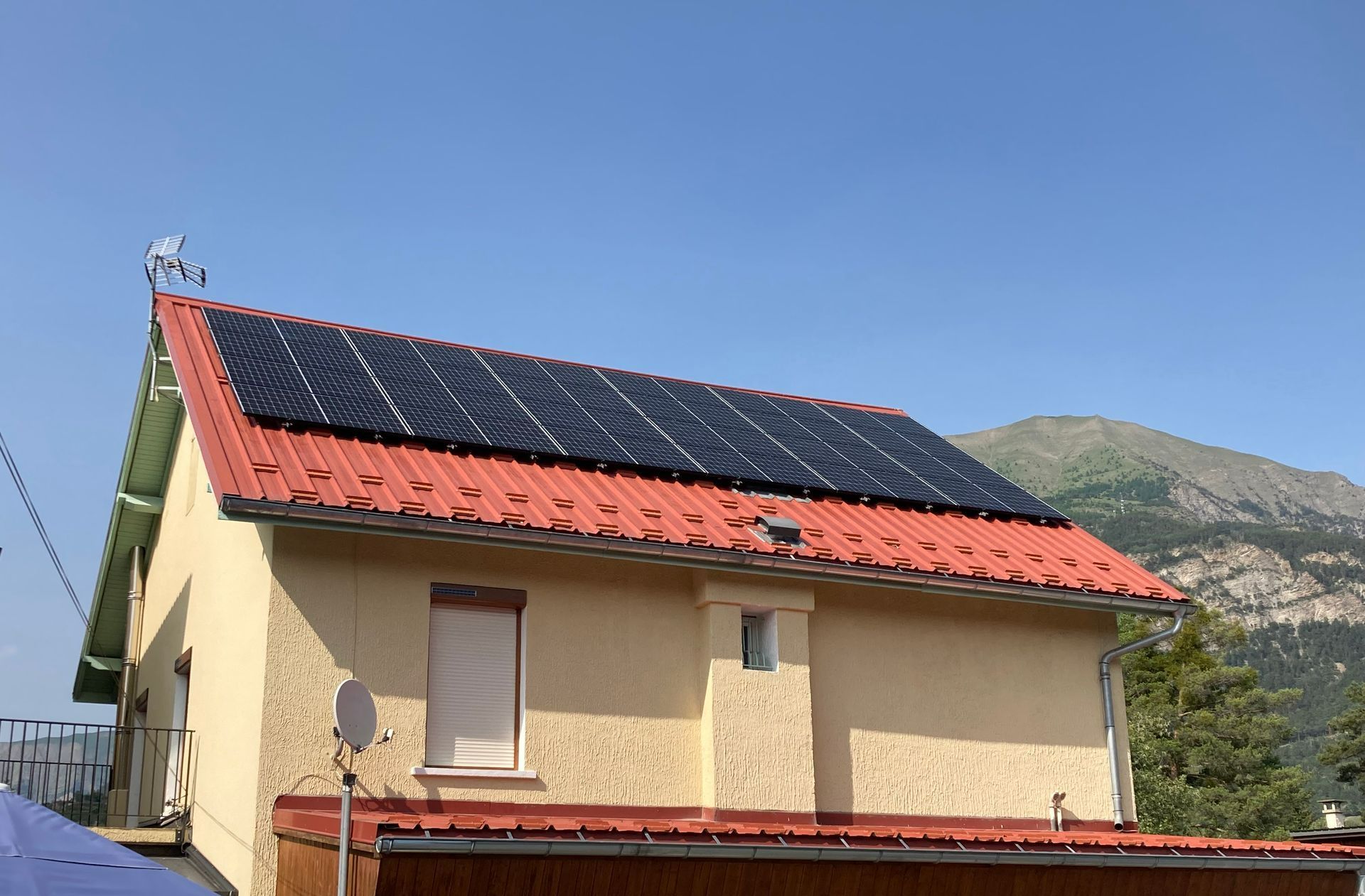 Maison au toit en zinc recouvert de panneaux photovoltaïques