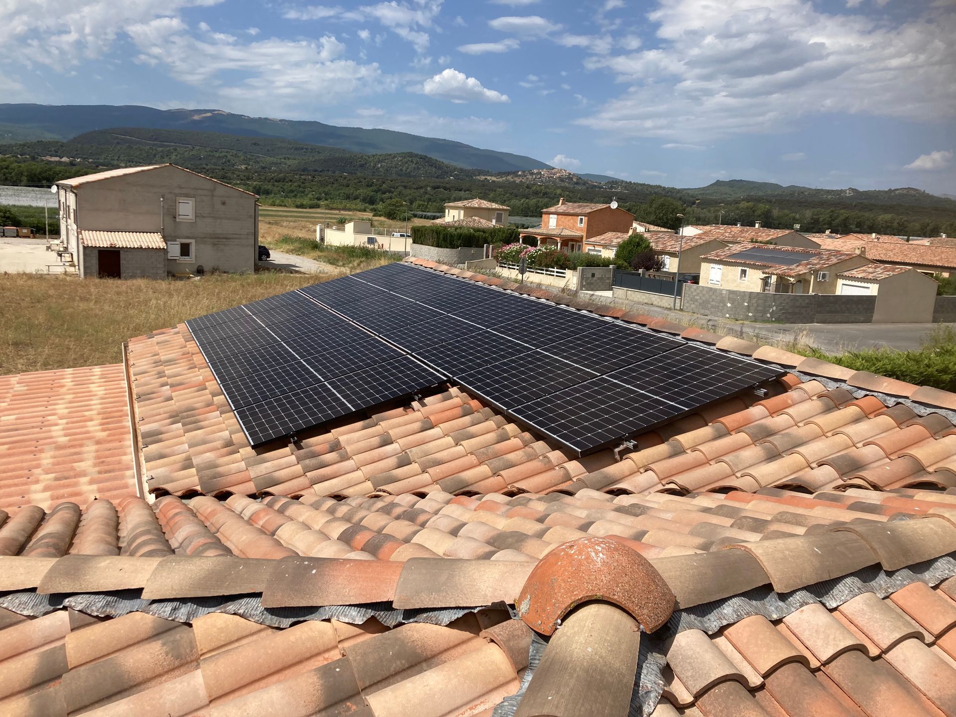 Une longue rangée de panneaux solaires sont disposés sur un toit d’une maison du sud