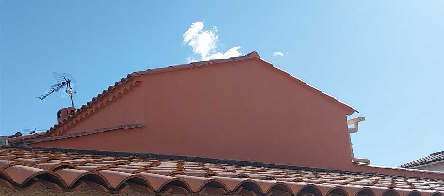 Un toit avec une antenne parabolique dessus et un ciel bleu en arrière-plan.