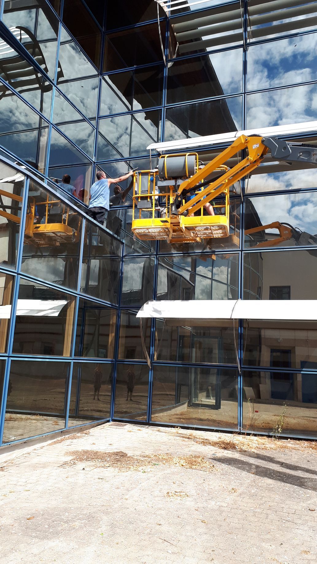 Deux personnes nettoient une baie vitrée