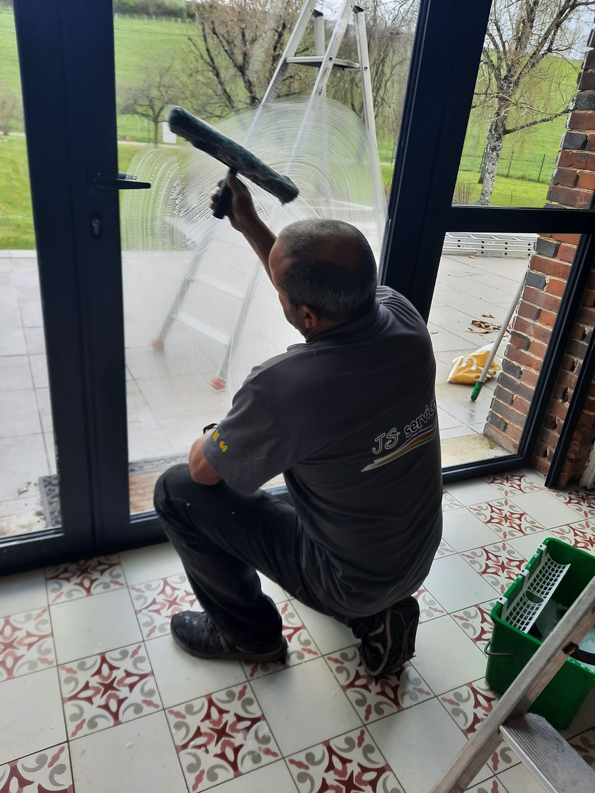 Un homme nettoie des vitres