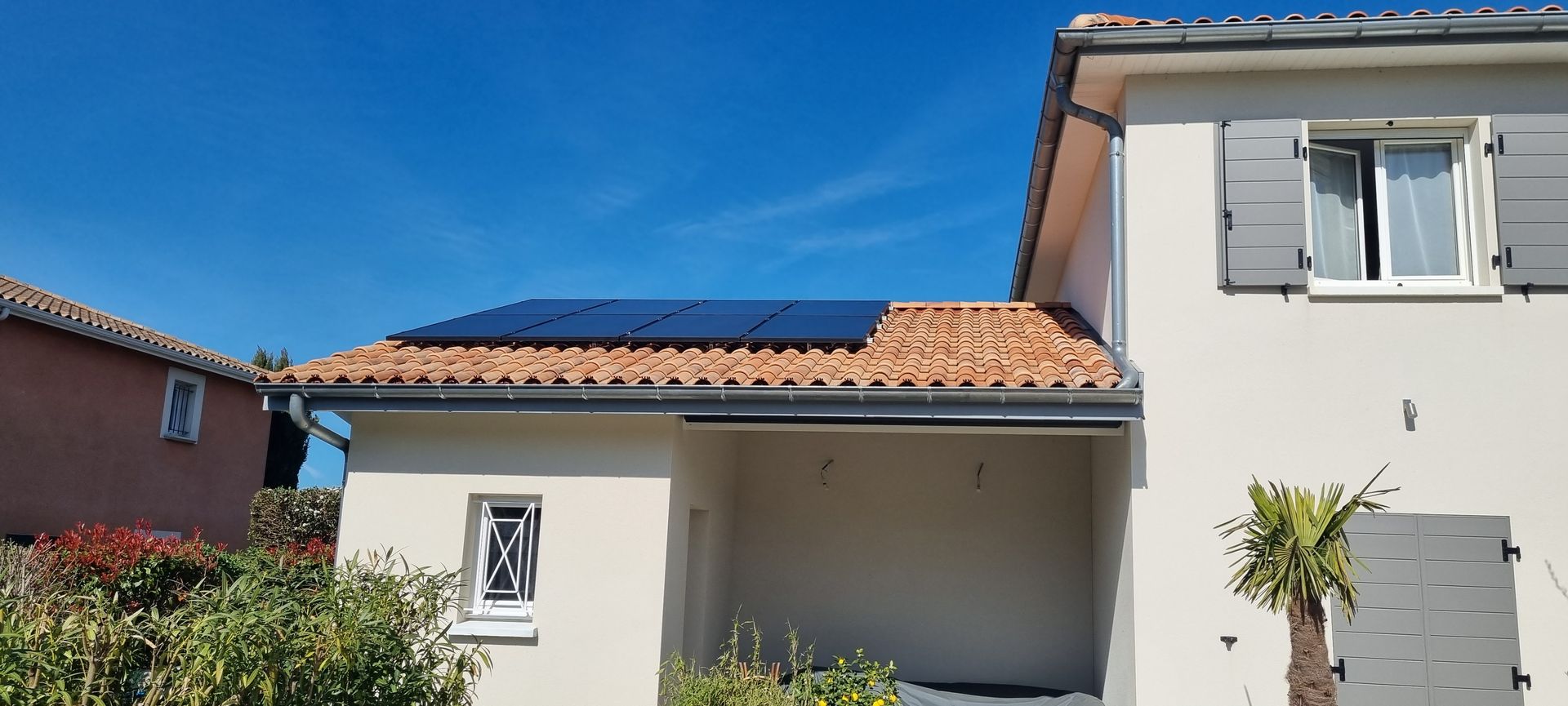 Immeuble résidentiel avec panneaux solaires sur le toit et ciel bleu.