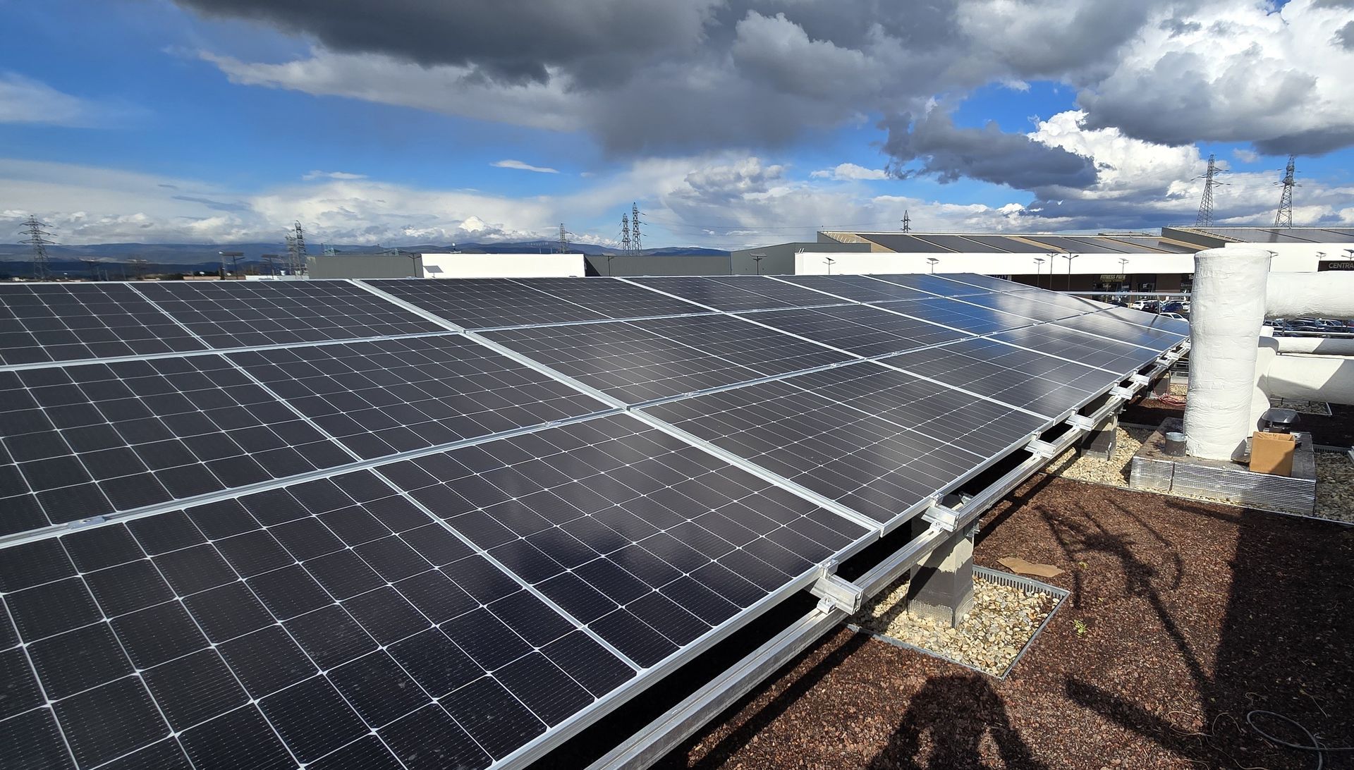 Panneaux solaires sur le toit d'un immeuble, se détachant sur un ciel nuageux.