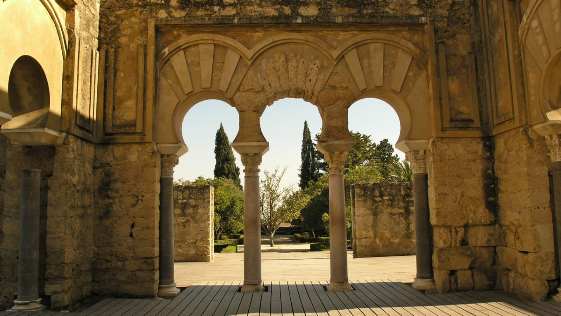 Un edificio muy antiguo con arcos y columnas y un cartel que dice 