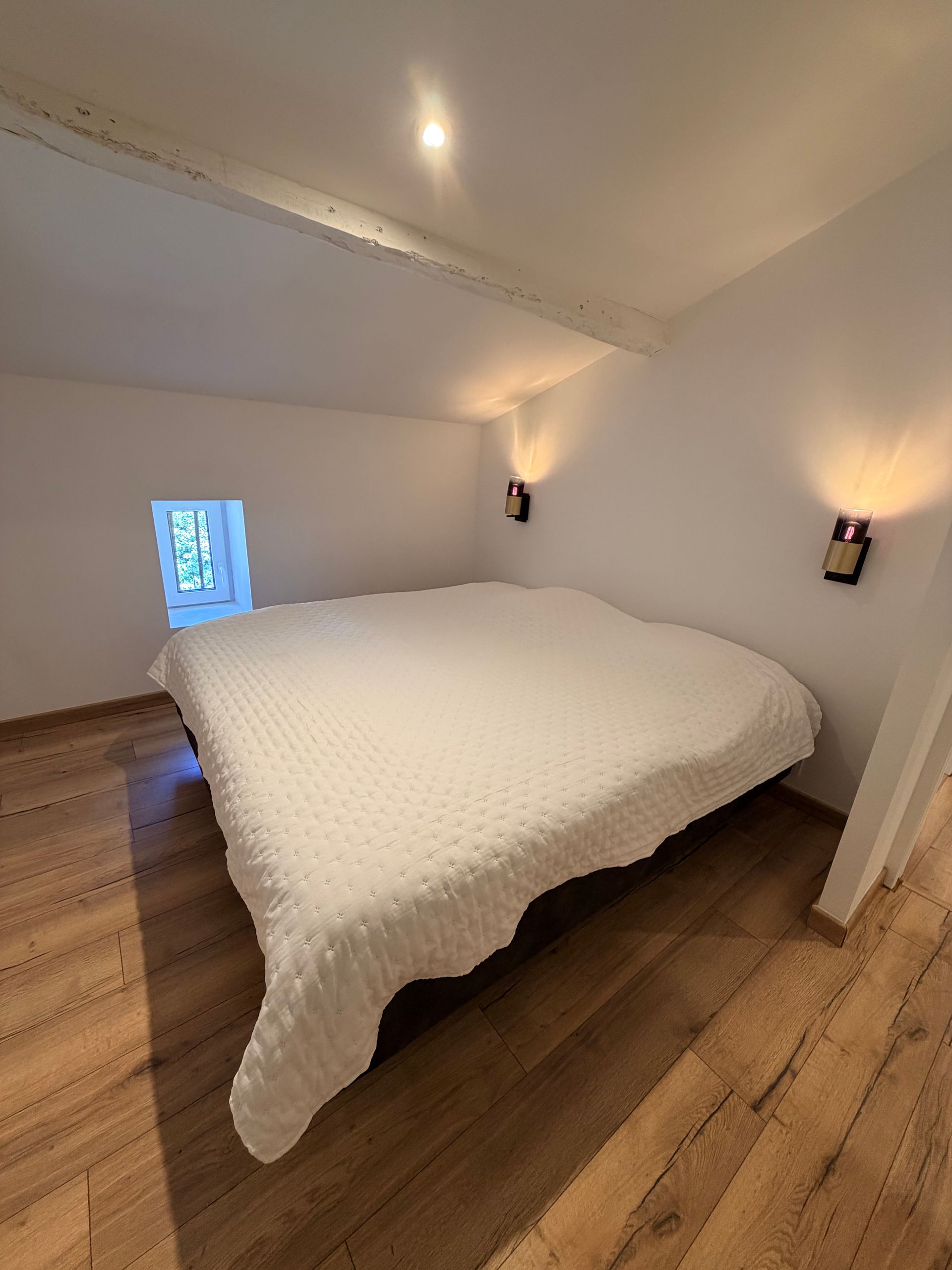 Chambre avec lit double sous les poutres de la maison
