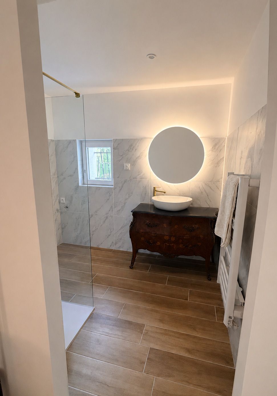 Salle de bains avec miroir rond au-dessus du meuble vasque