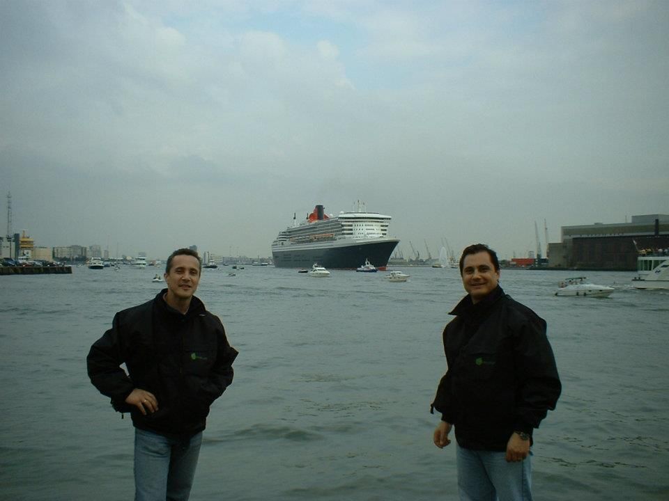 Dos hombres están parados frente a un gran crucero.