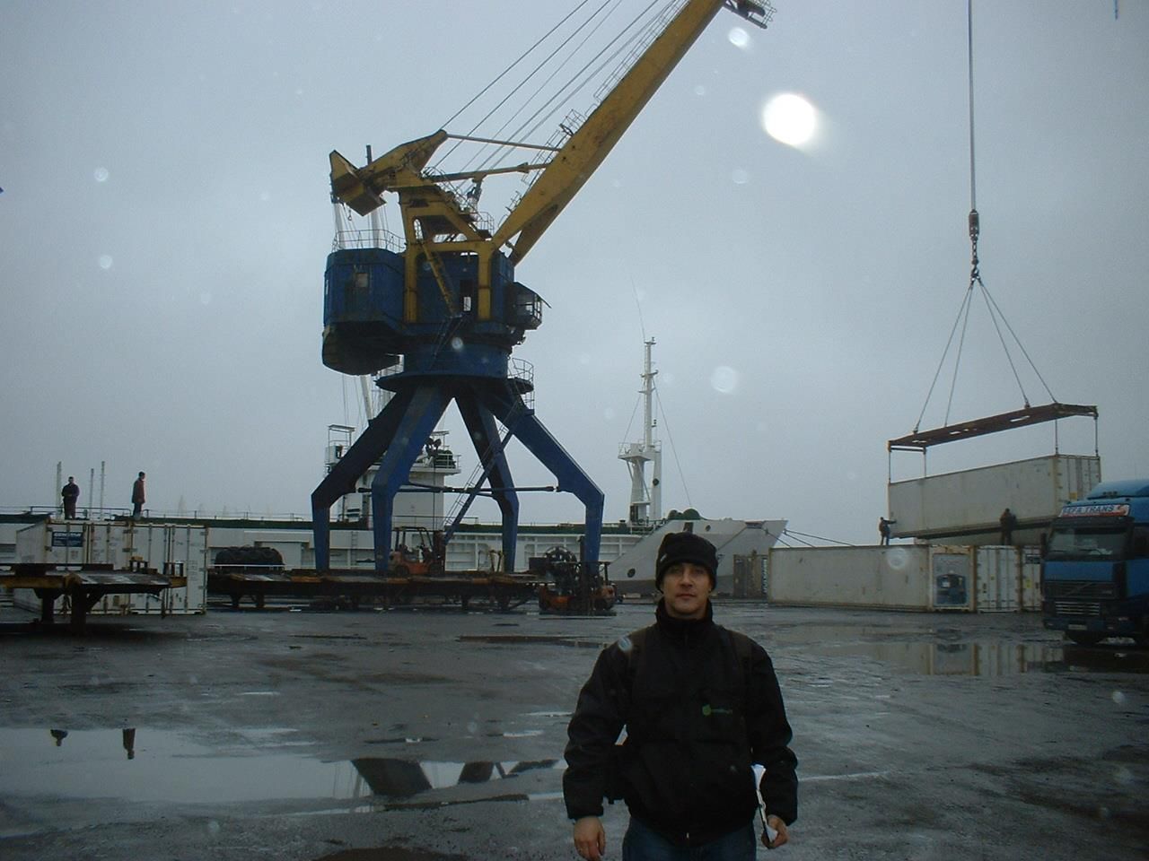 Un hombre parado frente a una gran grúa.