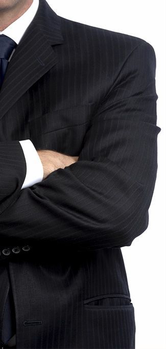 Un hombre con traje y corbata con los brazos cruzados